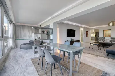 a living room with a table and chairs at South Blue Luxury Apartment in Vouliagmeni in Athens
