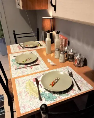 a table with plates and utensils on it at Beautiful Apartment in Koukaki 5min to Acropolis in Athens