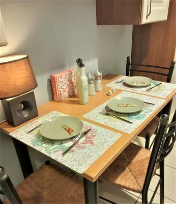 a wooden table with plates and utensils on it at Beautiful Apartment in Koukaki 5min to Acropolis in Athens