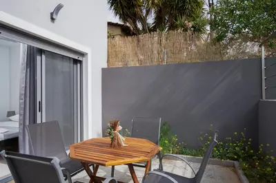 a wooden table and chairs on a patio at Luna Apartment by A&D Properties in Porto Rafti