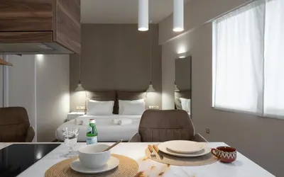 a room with a table with two chairs and a bed at Olvar Penthouse Apartment in Athens