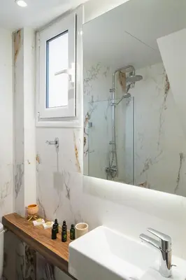 a bathroom with a sink and a mirror at Olvar Penthouse Apartment in Athens