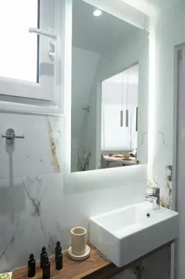 a white bathroom with a sink and a mirror at Olvar Penthouse Apartment in Athens