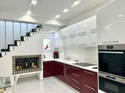 a kitchen with white cabinets and a staircase at Evilion Maisonette in Athens in Athens