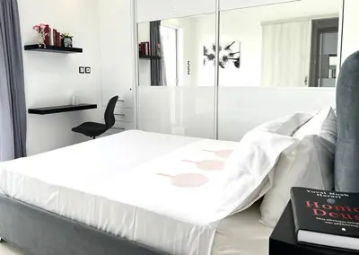 a bedroom with a white bed and a black chair at Evilion Maisonette in Athens in Athens