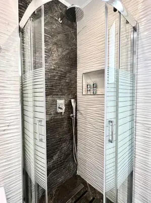a bathroom with a shower with a glass door at Evilion Maisonette in Athens in Athens