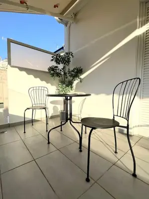 two chairs and a table on a balcony at Evilion Maisonette in Athens in Athens