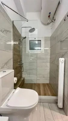 a white bathroom with a shower and a toilet at Theseus Retreat 10 min walk from the Acropolis in Athens
