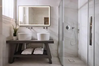 a bathroom with two sinks and a mirror and a shower at Acropolis Museum Grand Residence in Athens