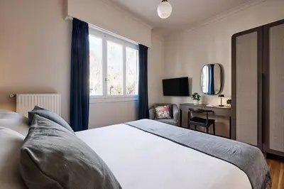 a bedroom with a bed and a desk and a window at Acropolis Museum Grand Residence in Athens