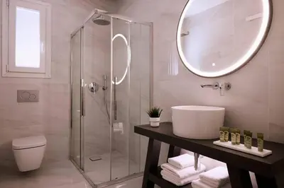 a bathroom with a shower and a sink and a mirror at Acropolis Museum Grand Residence in Athens