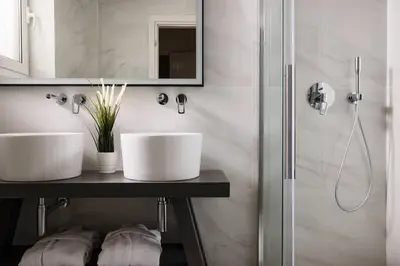 a bathroom with two sinks and a shower at Acropolis Museum Grand Residence in Athens