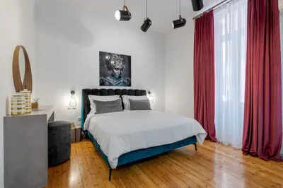a bedroom with a large bed with red curtains at 2 Mazi Suites in Athens