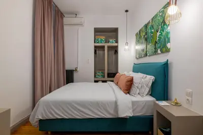 a bedroom with a bed with a blue headboard at 2 Mazi Suites in Athens