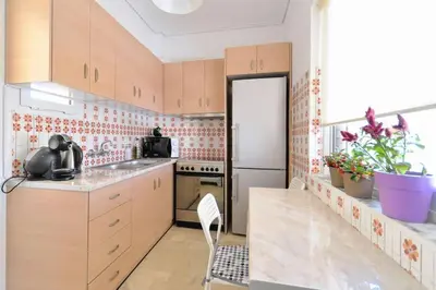 a kitchen with wooden cabinets and a white refrigerator at 2 level apartment with terrace and Acropolis view in Athens