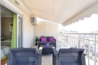 a balcony with chairs and a table and a couch at 2 level apartment with terrace and Acropolis view in Athens