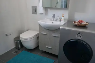 a bathroom with a sink and a washing machine at 2 level apartment with terrace and Acropolis view in Athens