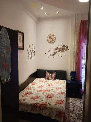 a bedroom with a bed and a clock on the wall at Διαμέρισμα στην καρδιά της Αθήνα in Athens