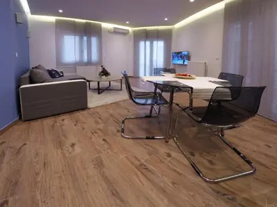 a living room with a table and chairs and a couch at Luxury apartment near Acropolis of Athens in Athens