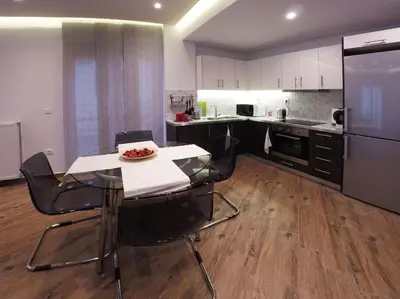 a kitchen with a table and chairs and a refrigerator at Luxury apartment near Acropolis of Athens in Athens