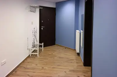 a hallway with blue walls and a wooden floor at Luxury apartment near Acropolis of Athens in Athens