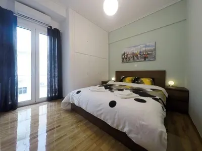a bedroom with a large bed and a large window at Cozy apartment close to Acropolis in Athens