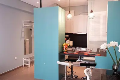 a kitchen and dining room with a table and chairs at Cozy apartment close to Acropolis in Athens