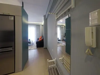 a room with a phone on the wall and a living room at Cozy apartment close to Acropolis in Athens