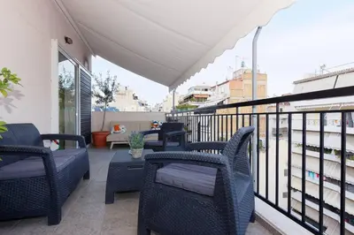 a balcony with wicker chairs and a table on a building at Big terrace near metro and Athens center in Athens