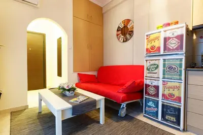 a living room with a red couch and a soda machine at Big terrace near metro and Athens center in Athens