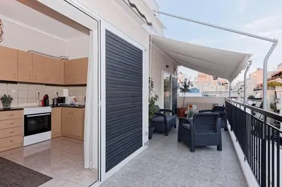 a kitchen and a balcony with a kitchen and a table at Big terrace near metro and Athens center in Athens