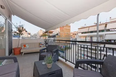 a balcony with chairs and a couch on a building at Big terrace near metro and Athens center in Athens