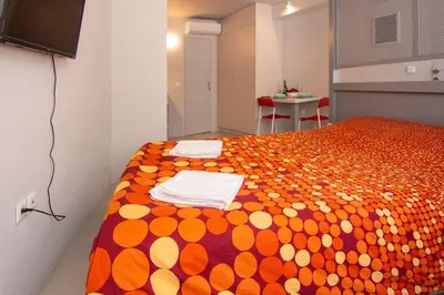 a bedroom with a bed with an orange and white blanket at Red cosy studio in Athens center in Athens