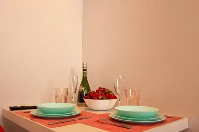 a table with two bowls and a bottle of wine at Red cosy studio in Athens center in Athens
