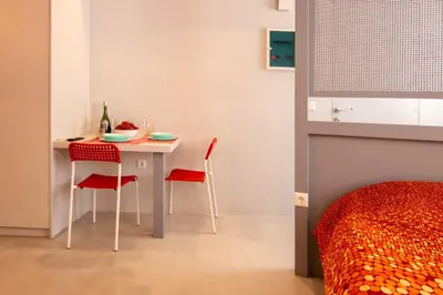 a table and chairs in a room with a bed at Red cosy studio in Athens center in Athens