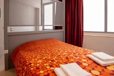 a bedroom with an orange bed with towels on it at Red cosy studio in Athens center in Athens