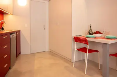 a kitchen with a table and a red chair at Red cosy studio in Athens center in Athens