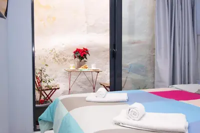 a room with a bed and a table with towels at Luxury studio in Greek island style in Athens