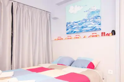 a bedroom with a bed and a painting on the wall at Luxury studio in Greek island style in Athens