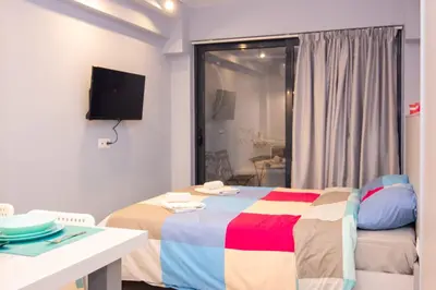 a bedroom with a bed and a tv on the wall at Luxury studio in Greek island style in Athens