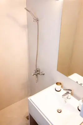 a bathroom with a white sink and a mirror at Luxury studio in Greek island style in Athens