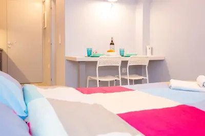 a bedroom with a bed and a table with chairs at Luxury studio in Greek island style in Athens
