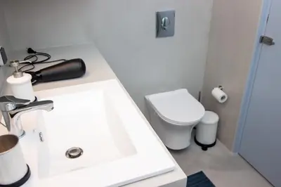 a bathroom with a white sink and a toilet at Luxury studio in Greek island style in Athens
