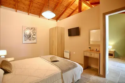 a bedroom with a bed and a desk and a television at GK Mediterranean Village - Airport Free Shuttle by GK Properties in Markopoulo