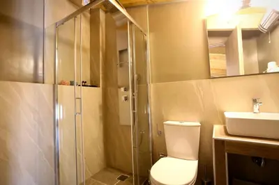 a bathroom with a shower and a toilet and a sink at GK Mediterranean Village - Airport Free Shuttle by GK Properties in Markopoulo