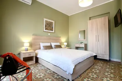a bedroom with a large bed and two night stands at GK Mediterranean Village - Airport Free Shuttle by GK Properties in Markopoulo