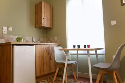 a kitchen with a white refrigerator and a table at GK Mediterranean Village - Airport Free Shuttle by GK Properties in Markopoulo