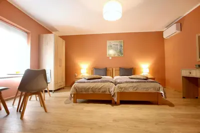 a bedroom with a bed with orange walls at GK Mediterranean Village - Airport Free Shuttle by GK Properties in Markopoulo