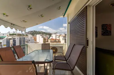 a balcony with a glass table and chairs at Penthouse 2Bd apartment in the heart of Koukaki in Athens