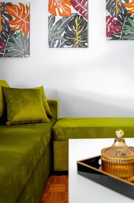 a living room with a green couch and a table at Penthouse 2Bd apartment in the heart of Koukaki in Athens